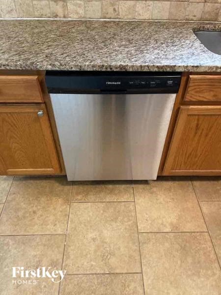 a stainless steel dishwasher sitting under a kitchen counter