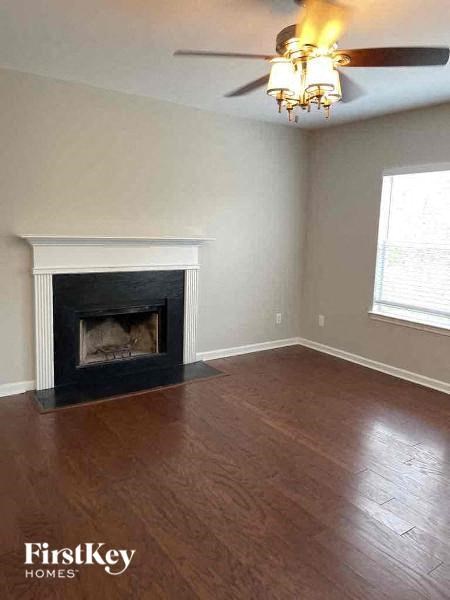 a living room with a fireplace and a ceiling fan