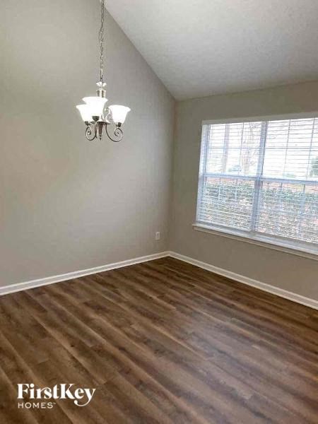 an empty living room with wood floors and a window