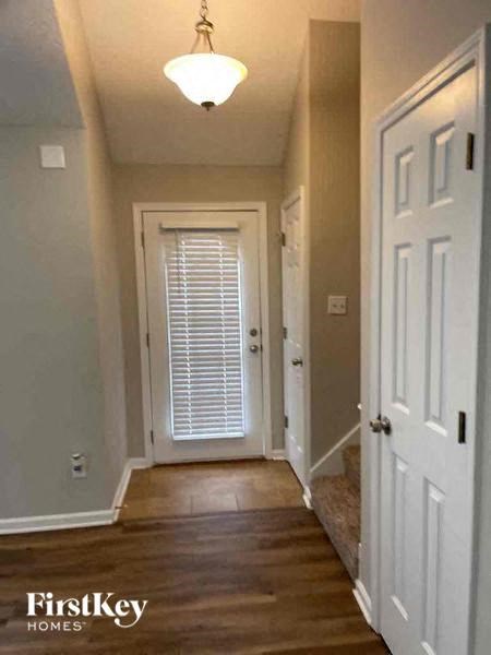 a hallway with a white door and a door to a bedroom