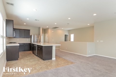 A spacious kitchen with dark cabinets and a light countertop.
