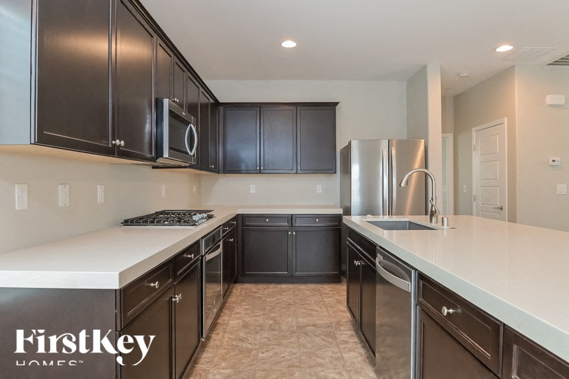 A kitchen with dark brown cabinets and stainless steel appliances.