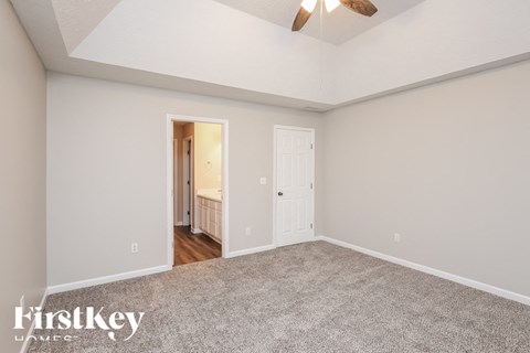 a living room with carpet and a ceiling fan