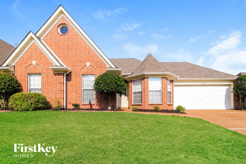a brick house with a lawn in front of it