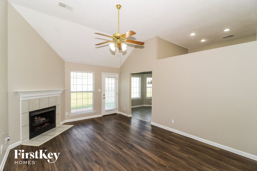 a living room with a fireplace and a ceiling fan