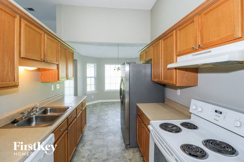 a kitchen with wooden cabinets and a stove and a refrigerator