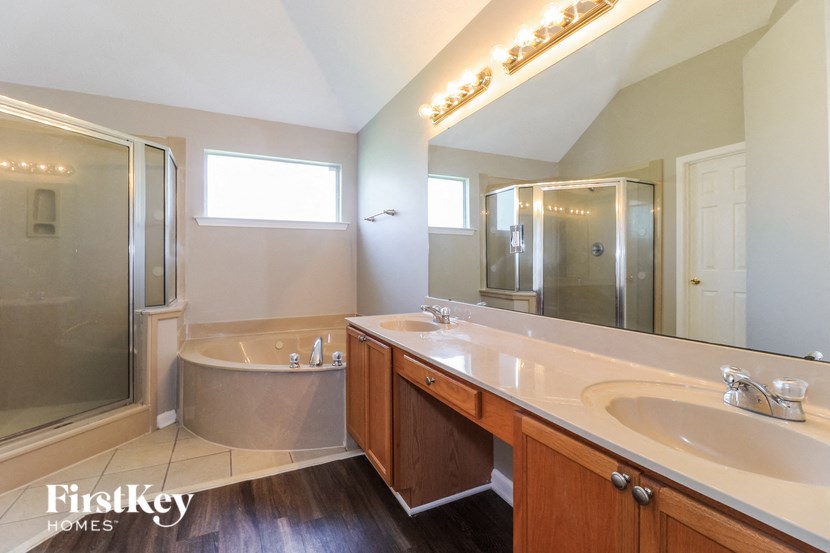 a large bathroom with a tub and a sink and a mirror