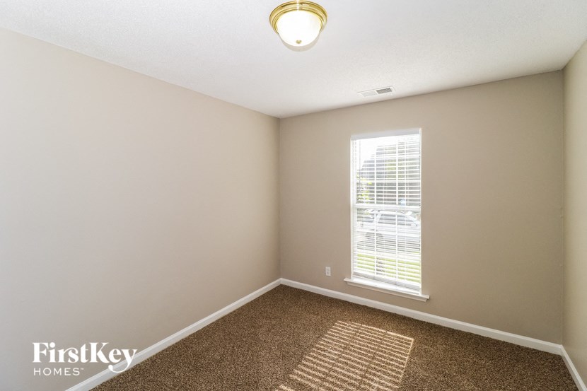 an empty room with a window and a carpet