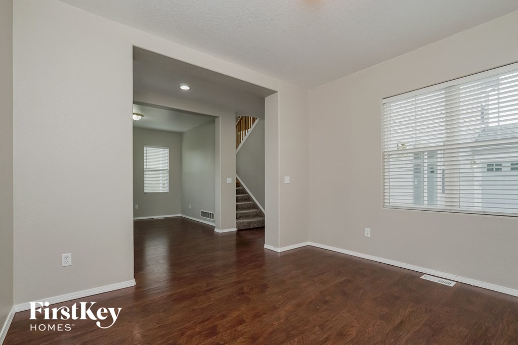 a living room with a large window and wood flooring