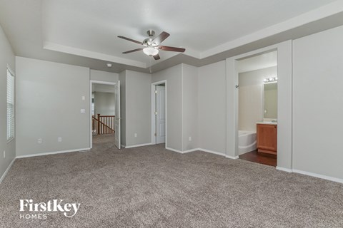 a living room with carpet and a ceiling fan