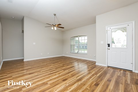 a living room with hardwood floors and a white door
