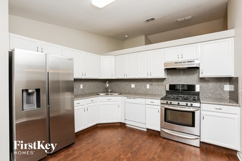 a kitchen with white cabinets and stainless steel appliances
