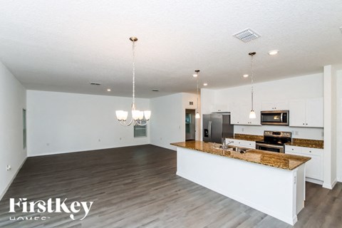 A kitchen with a wooden island and a refrigerator in the background.