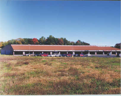 a red barn with cars parked in a field
