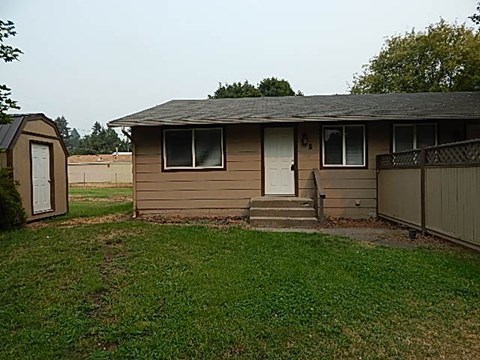 a small house with a yard and a fence