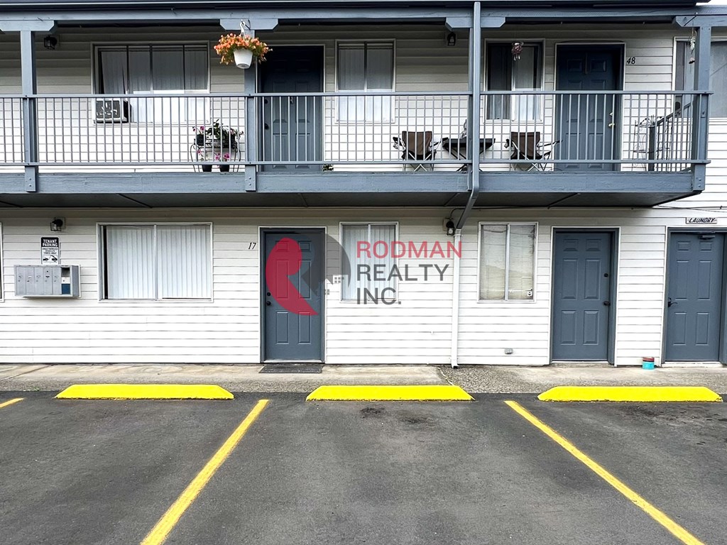 A building with a red sign that says Rodman Realty Inc.