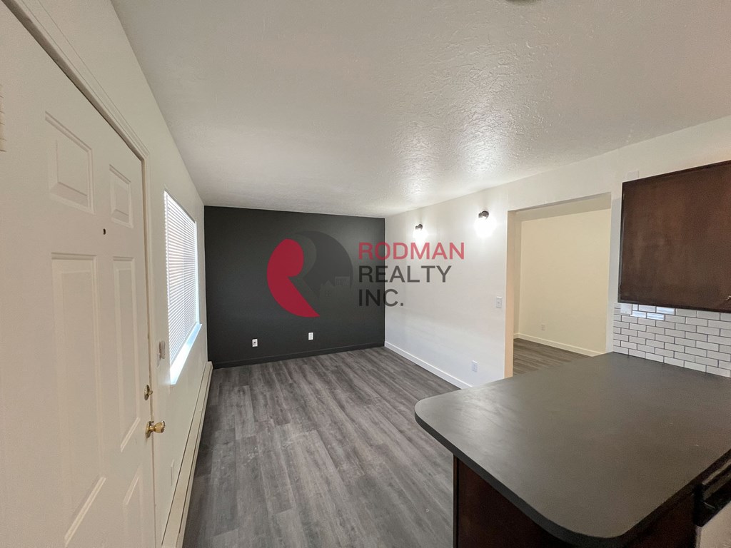 A room with a Rodman Realty Inc. sign on the wall.
