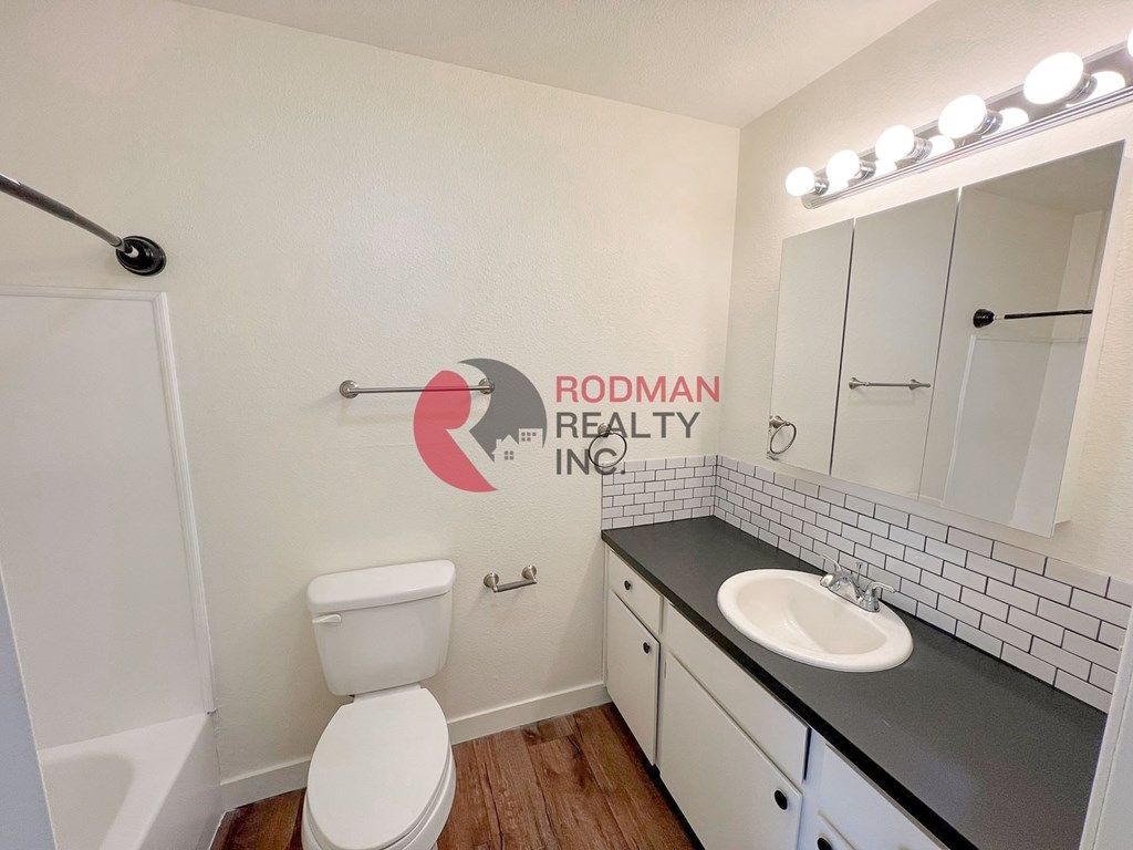 A bathroom with Rodman Realty logo on the wall.