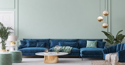 a living room with blue couches and lamps and a green wall