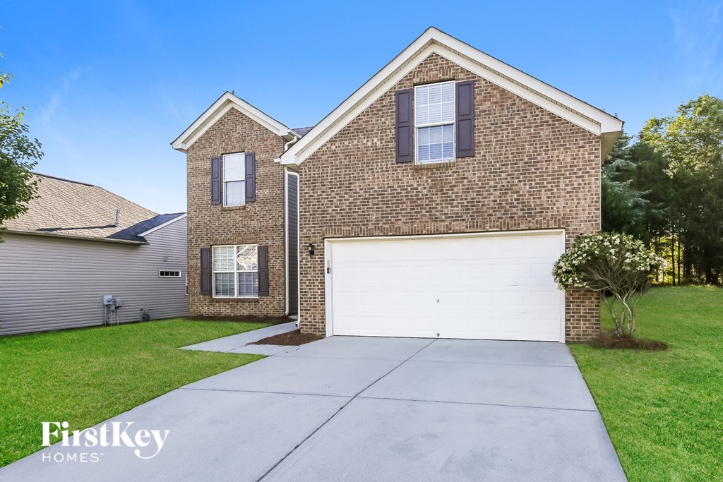 A brick house with a garage is for sale.