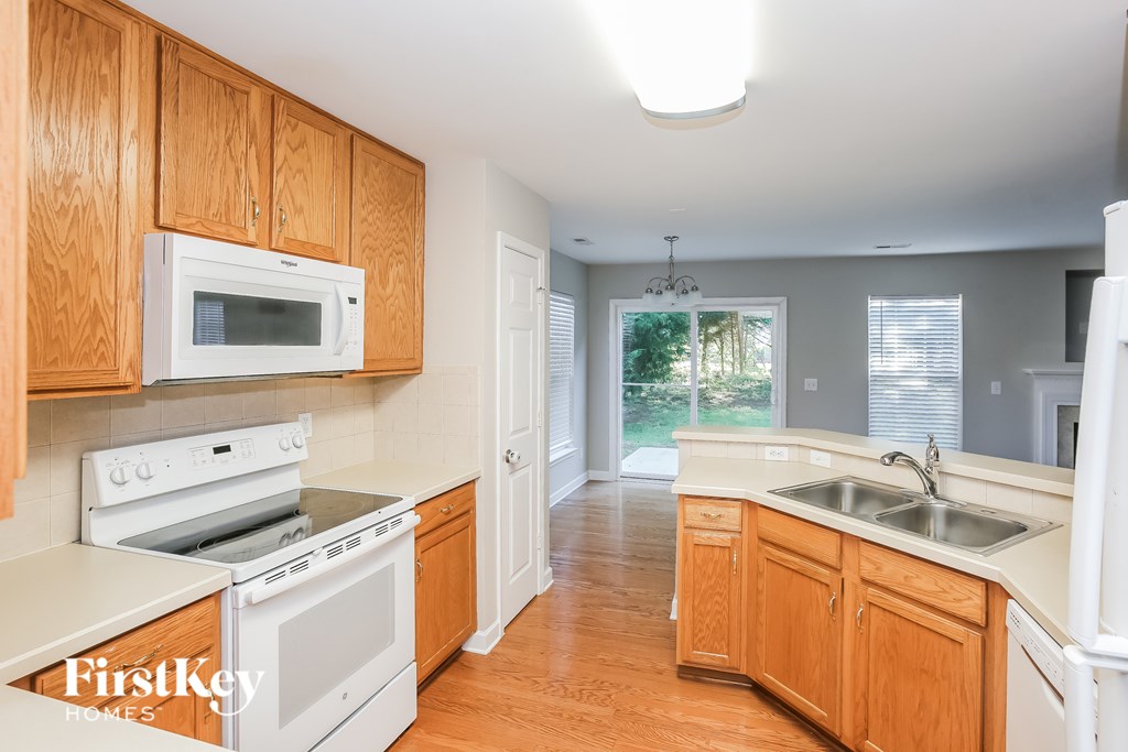A kitchen with wooden cabinets and white appliances.