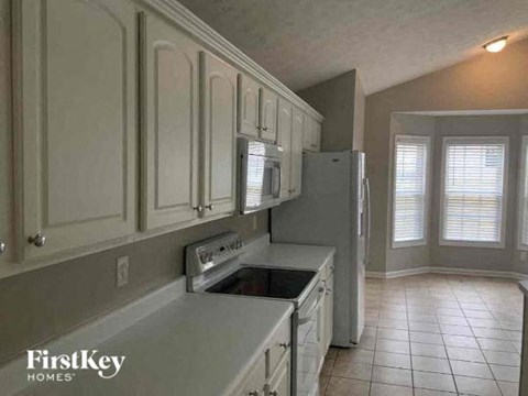 A kitchen with white cabinets and a stainless steel dishwasher.