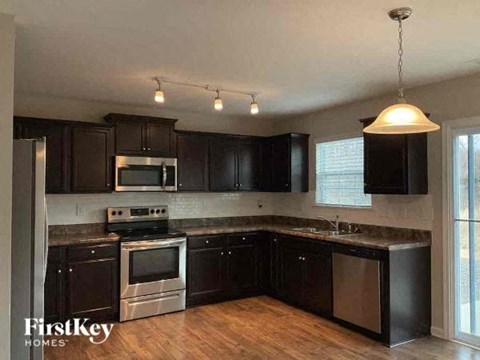 a kitchen with black cabinets and stainless steel appliances