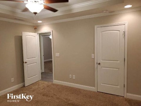 a living room with two doors and a ceiling fan