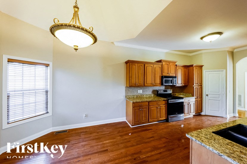 A kitchen with wooden cabinets and a granite countertop.