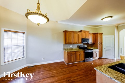 A kitchen with wooden cabinets and a granite countertop.