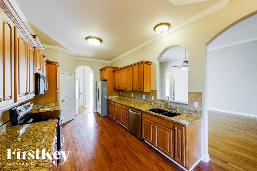 A kitchen with wooden cabinets and a granite countertop.