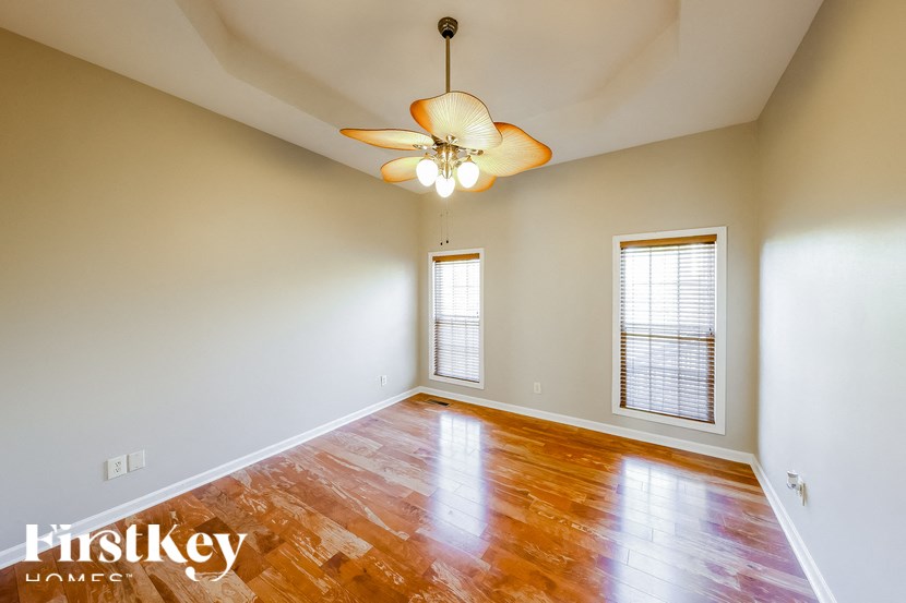 A room with a wooden floor and a ceiling fan.