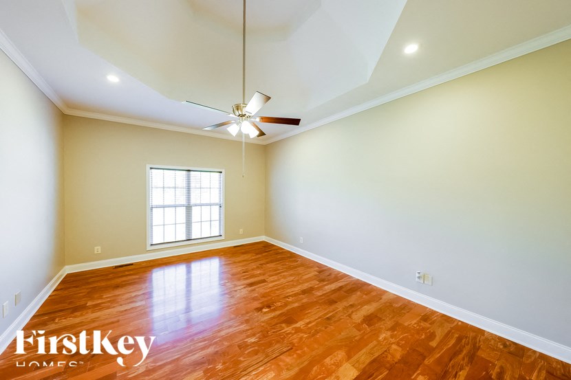 A room with a wooden floor and a ceiling fan.