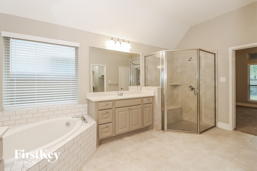 A bathroom with a tub, sink, and shower.