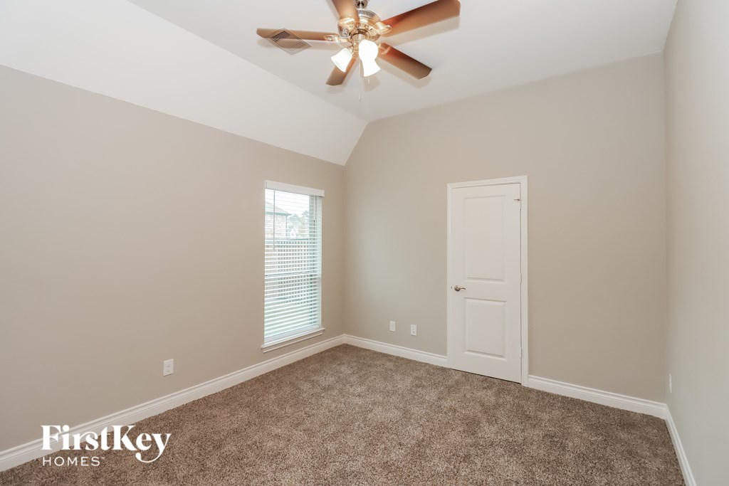 A room with a ceiling fan and a door.