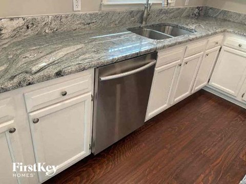 a kitchen with white cabinets and a stainless steel sink