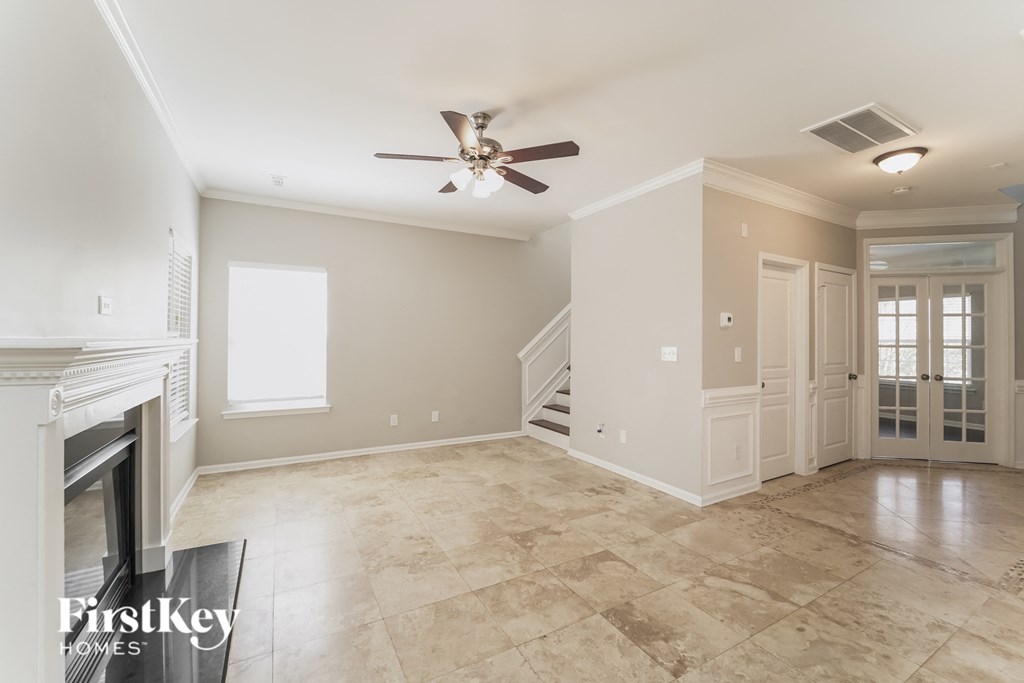 a empty living room with a fireplace and a ceiling fan