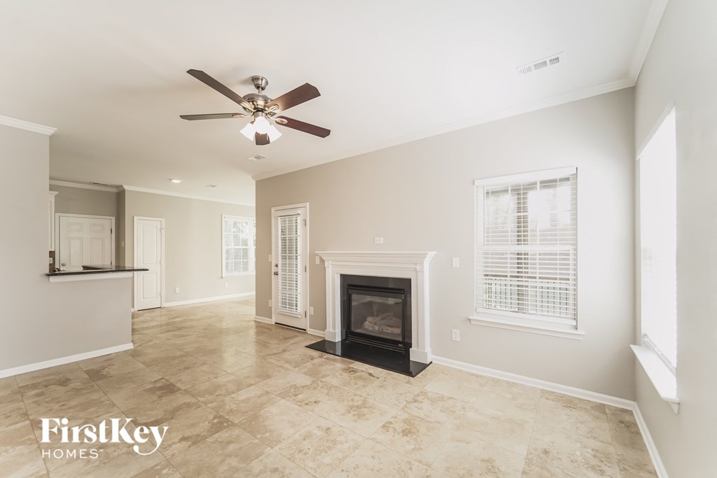 a living room with a fireplace and a ceiling fan
