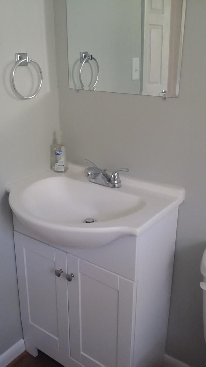 a bathroom with a white sink and a mirror