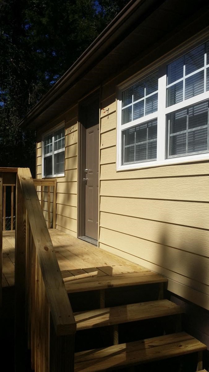 the front door is open to the porch of the cabin