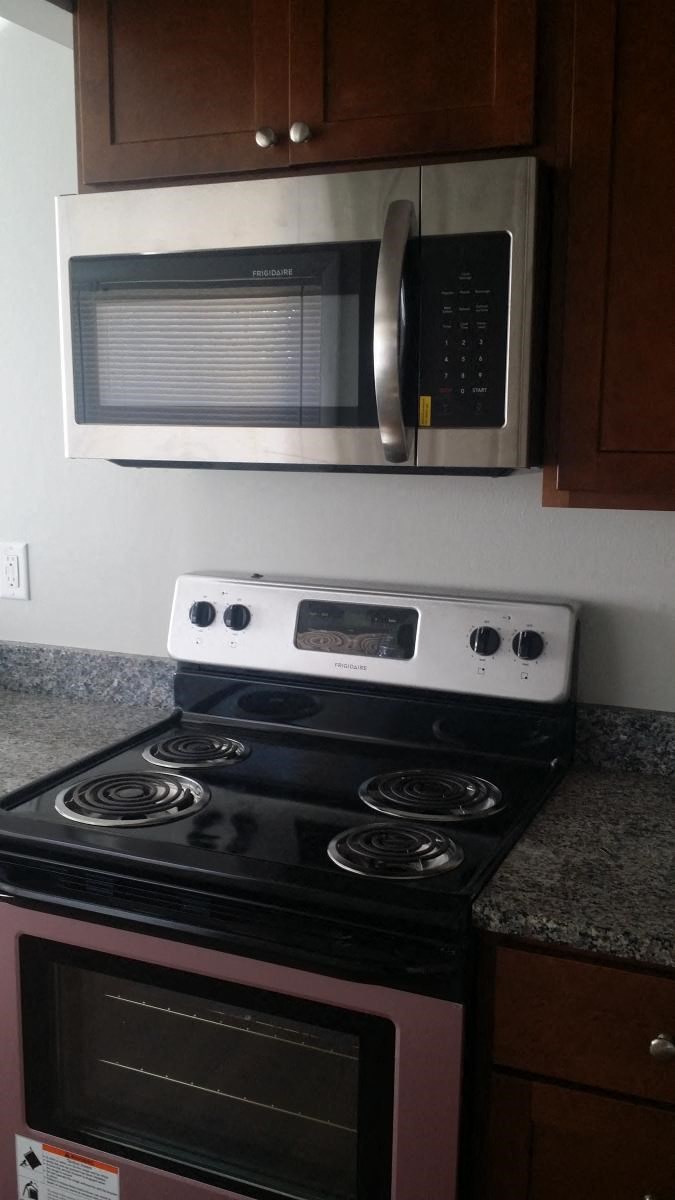 a kitchen stove with a microwave above it