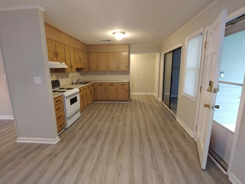 A kitchen with wooden cabinets and a white stove top oven.