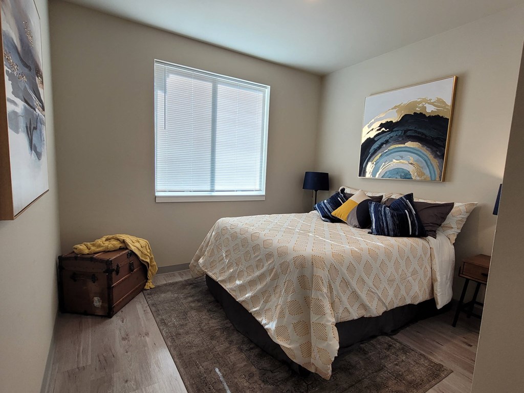 a bedroom with a bed and a painting on the wall