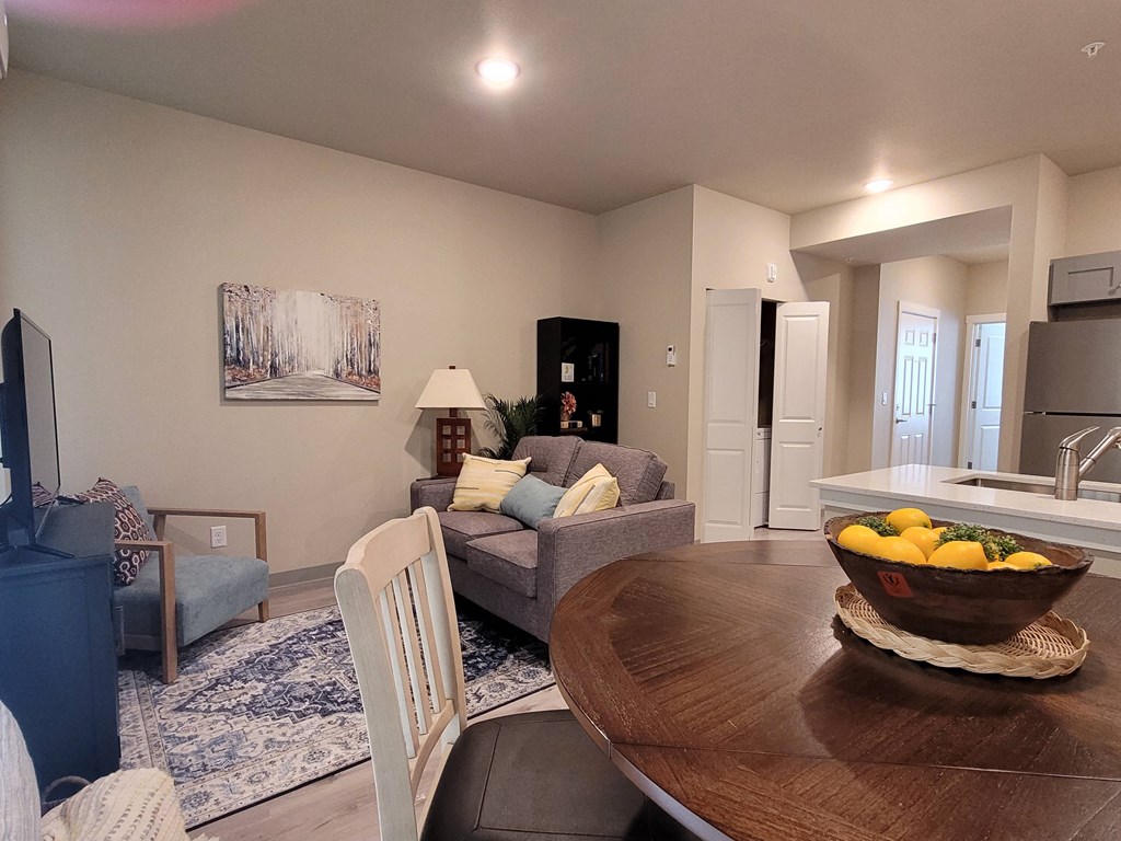 a living room and dining room with a table with fruit on it