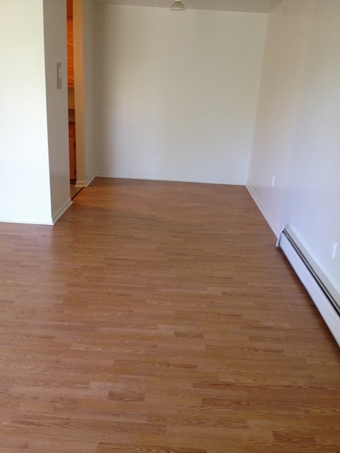 A room with wooden flooring and white walls.