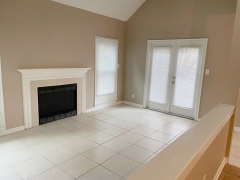a living room with a fireplace and a white tiled floor