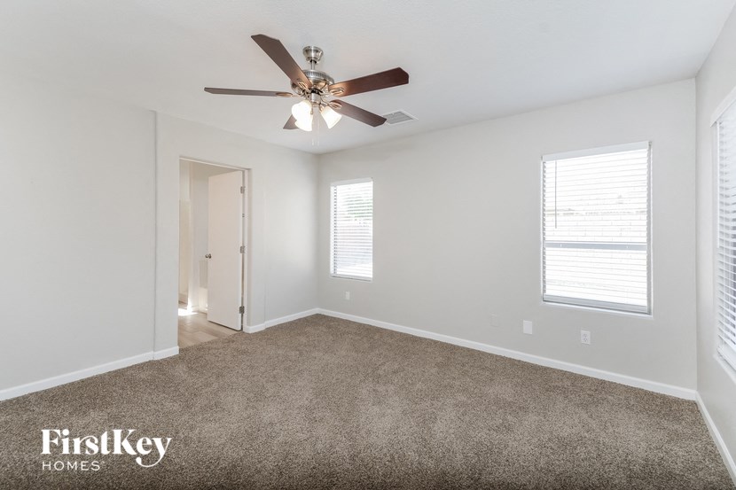 a bedroom with a ceiling fan and a carpeted floor
