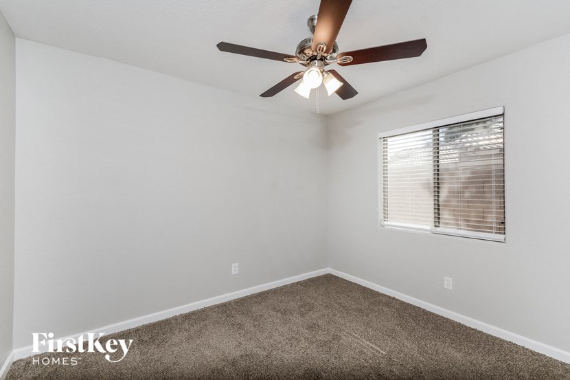 a bedroom with a ceiling fan and a window
