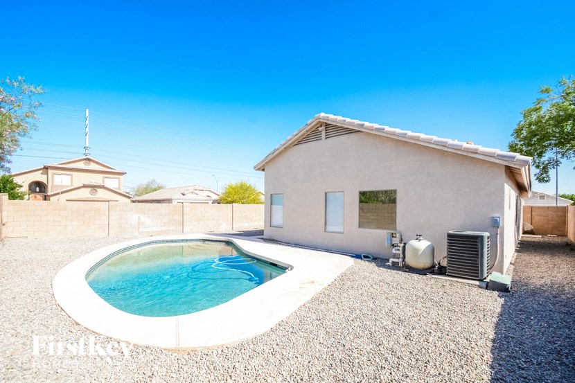 a pool in front of a house with a small pool