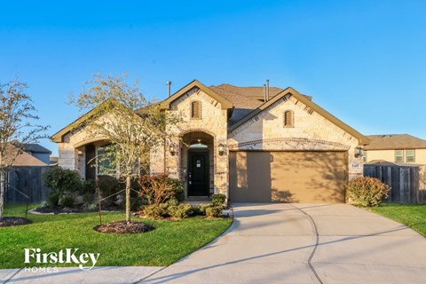 a single story home with a tan brick exterior and a driveway
